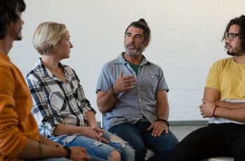 Man gesturing while talking to friends Man gesturing while talking to friends in art class