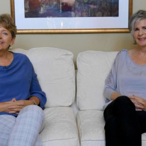 2 women sitting on couch