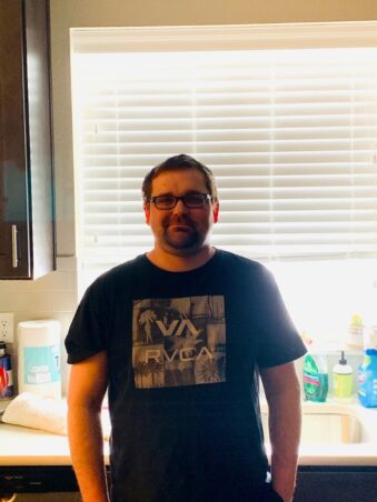 pat guy with glasses standing in kitchen